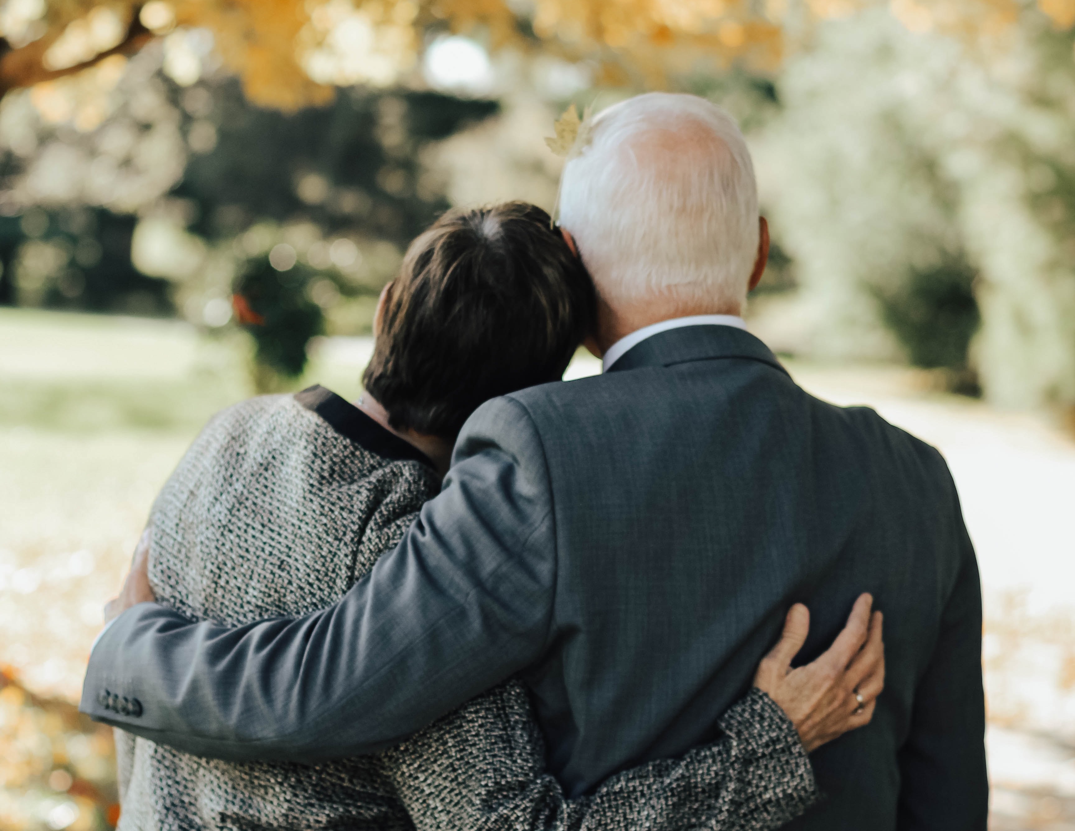 a couple stands together under a tree