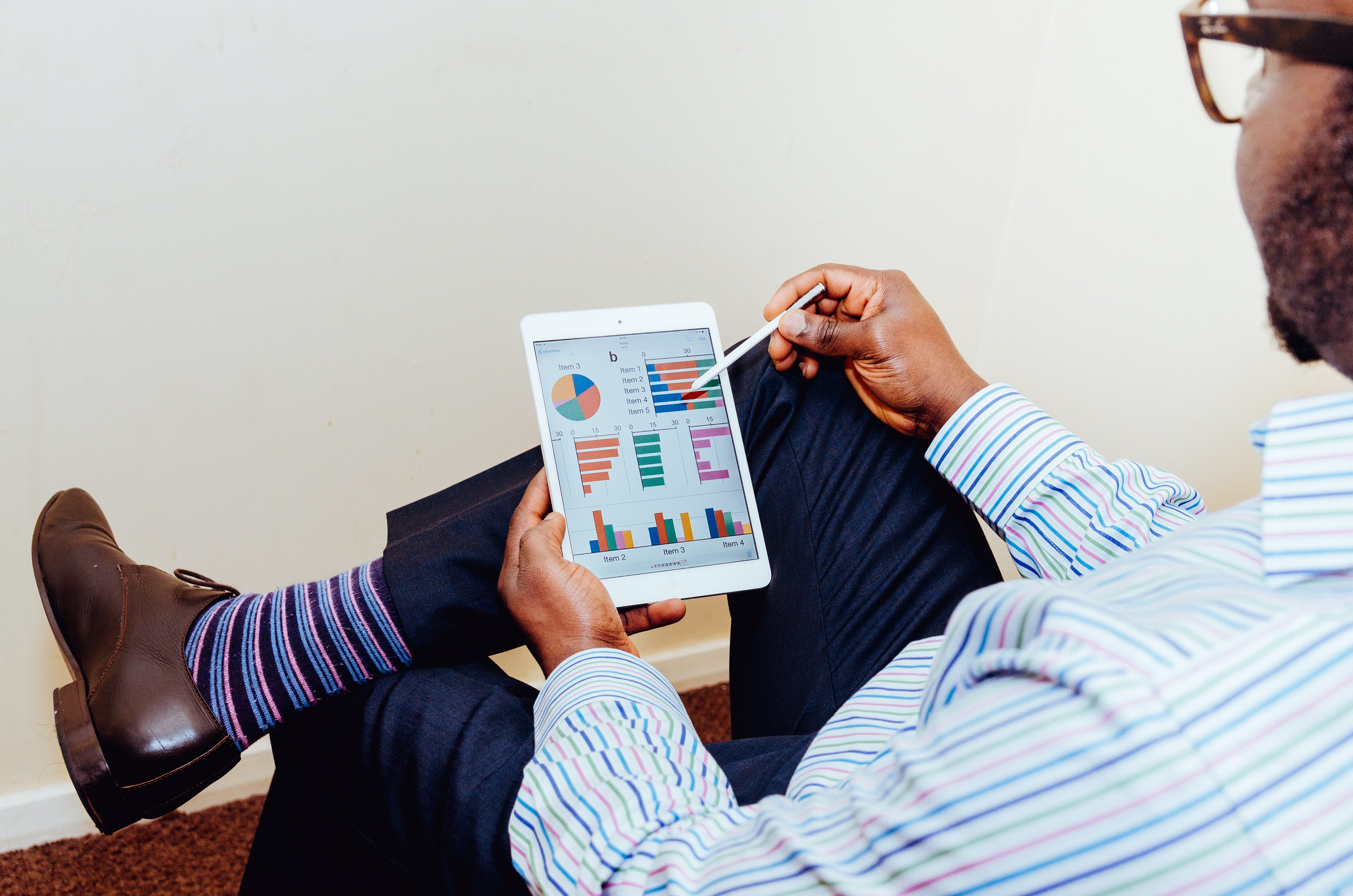 A man looks at graphs and charts on a tablet